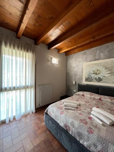 a bedroom with a bed and a large window at Copelia - Pool and Elegance in Paratico