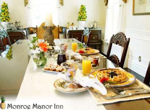 a dining room table with plates of food on it at Monroe Manor Inn in South Haven