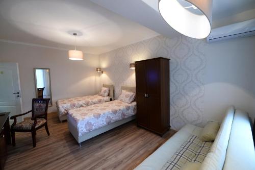 a bedroom with two beds and a cabinet and a chair at Calla Bella Rooms & Snack Bar in Skopje