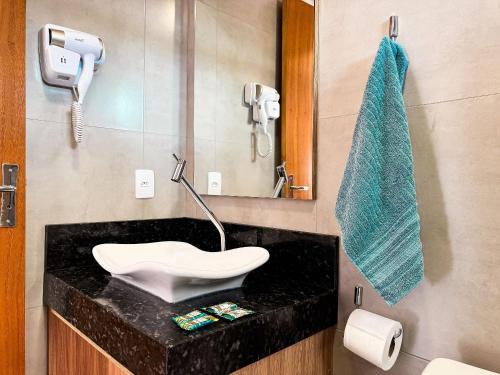 a bathroom with a sink and a mirror at Centro - flat completo para 4 pessoas in Brusque