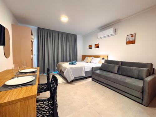 a hotel room with a bed and a couch at Centro - flat completo para 4 pessoas in Brusque