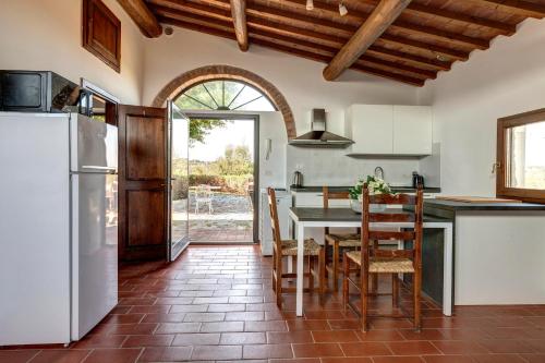 a kitchen with a table and chairs and a refrigerator at Agriturismo Le Mortinete in L'Ugolino