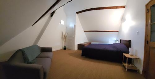 a bedroom with a bed and a couch in a room at La Petite Rochette in Chédigny