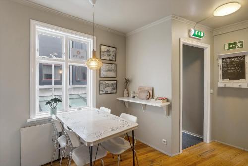 a dining room with a white table and chairs at Grettir Guesthouse Downtown Charm in Reykjavík