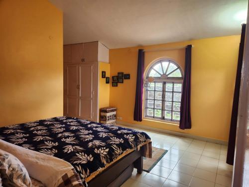 a bedroom with a bed and a window at Hideout by Cloudwalks in Kodaikānāl