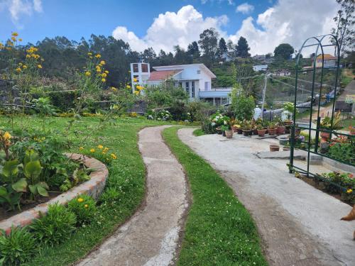 a dirt road in a garden with flowers at Hideout by Cloudwalks in Kodaikānāl