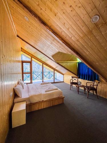 a bedroom with a large bed in a wooden ceiling at The Blue Mont Sojha Jibhi in Shoja