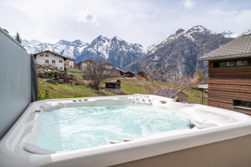 a jacuzzi tub with a view of mountains at Sera Lodge in Grächen