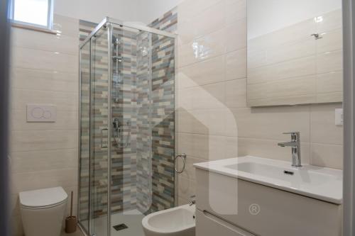 a bathroom with a toilet and a sink and a shower at Homiday - Appartamento Via Roma, 32 in Pineto