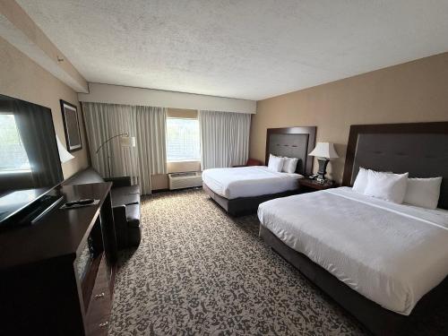 a hotel room with two beds and a television at Grand Oaks Hotel in Branson