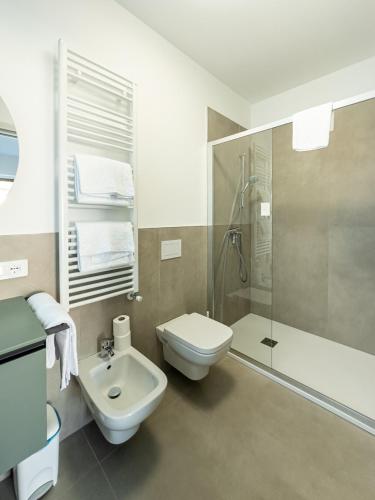 a bathroom with a toilet and a shower and a sink at North Wind Camping & Apartment in Domaso
