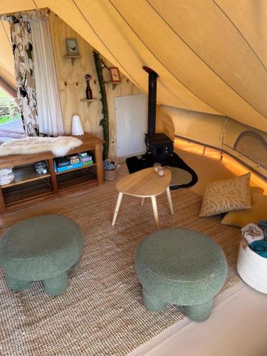 a room with a tent with two benches and a table at Belltent 't Bievink - buitengewoon overnachten in Westendorp