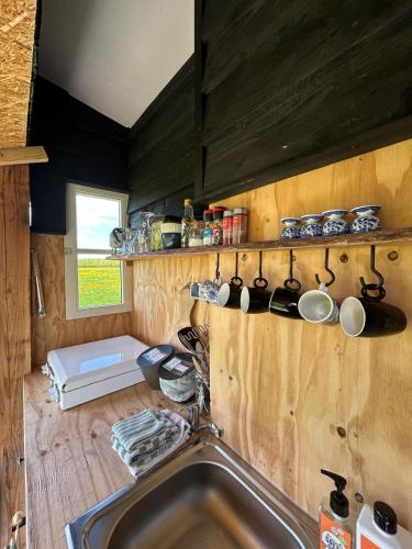 a kitchen with a sink and a counter with pots and pans at Belltent 't Bievink - buitengewoon overnachten in Westendorp