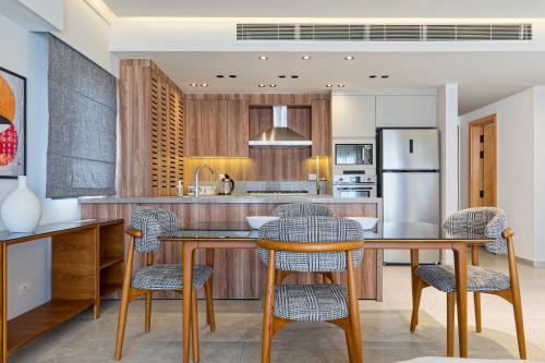 a kitchen with a table and chairs and a refrigerator at VESTA - Maison Zayed City in Sheikh Zayed