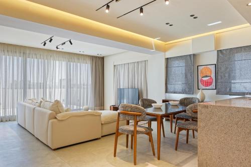 a living room with a couch and a table at VESTA - Maison Zayed City in Sheikh Zayed