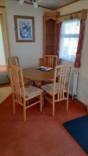 a dining room table with two chairs and a table at The discovery whitehouse towyn in Kinmel Bay