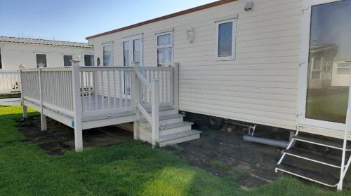 a mobile home with a staircase next to a house at The discovery whitehouse towyn in Kinmel Bay