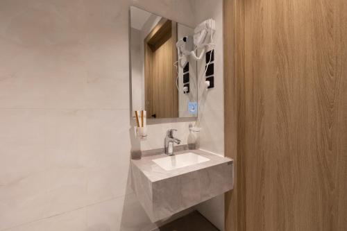 a bathroom with a sink and a mirror at فندق أجنحة رواق in Medina