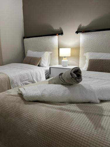 a towel laying on top of two beds in a room at Casa Bonheur in Windhoek