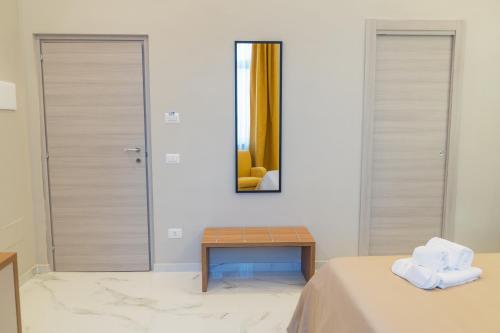 a bedroom with a bed and a table and a mirror at Le Suite in Crotone