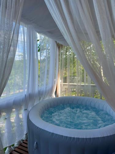 a large hot tub in a room with a window at Vikendica Cokori - private pool and jacuzzi in Banja Luka