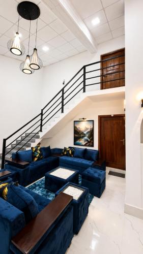 a living room with blue couches and a staircase at Thambara Resort in Polonnaruwa