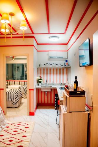 a kitchen with red and white striped walls and a counter at Chick Nina Loft in Barra do Garças