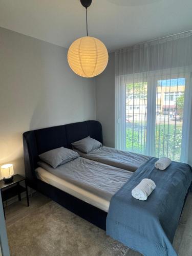a bedroom with a bed and a large window at Misa Home in Nyíregyháza