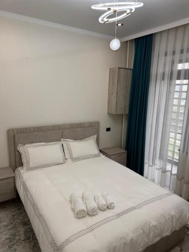 a bedroom with a large white bed with two towels on it at ЖК Сити Парк in Osh