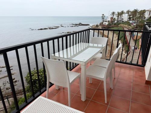 a balcony with a table and chairs and the ocean at Balcon Del Mar Primera Linea de Playa in La Cala de Mijas