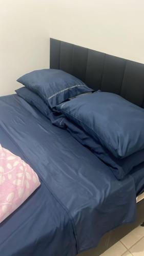 a bed with blue pillows on top of it at Quartos Viracopos independente in Campinas