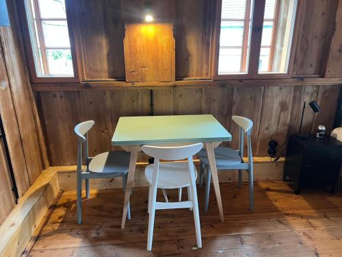a table and chairs in a room with wooden walls at Faktorei 312 in Eibau