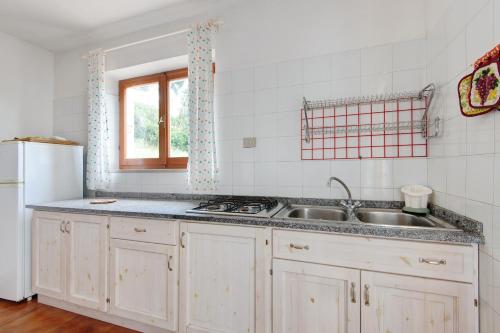 a white kitchen with a sink and a refrigerator at Hause Sant'Ilario in Campo nell'Elba