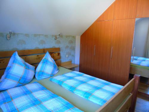 a bedroom with two beds and a wooden cabinet at Ferienwohnung Csilla in Unterweid