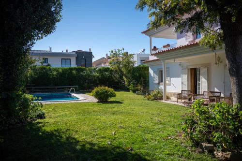 a backyard of a house with a swimming pool at Casa do Marmeleiro Guest House Cascais in Cascais