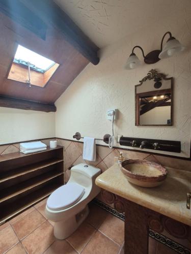 a bathroom with a toilet and a sink and a mirror at Casa de los Arcángeles in San Cristóbal de Las Casas