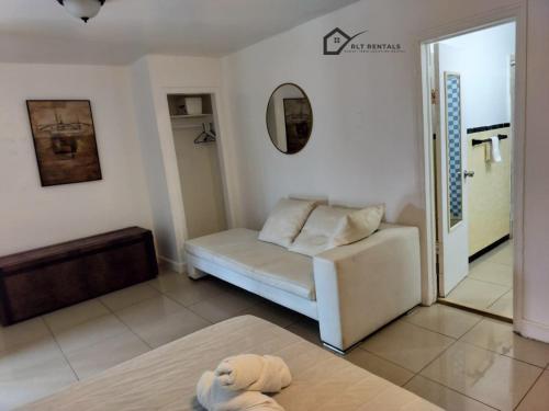 a living room with a white couch and a mirror at Comfortable Large Studio-J in Hollywood