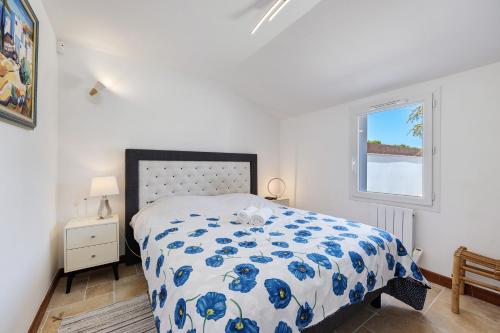 a bedroom with a bed with a blue and white comforter at Villa Bleu Azur - piscine, plages in Angles