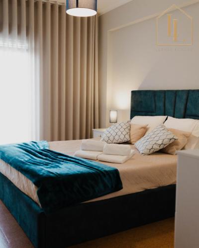 a bedroom with a large bed with a blue headboard at Casa da Amorosa by Lethes Legacy in Abelheira