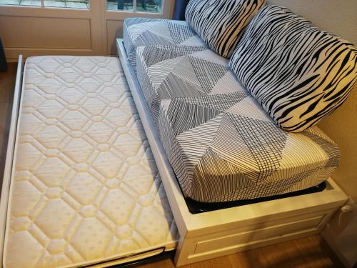 a bed sitting next to a pillow on a floor at Studio in Argentat