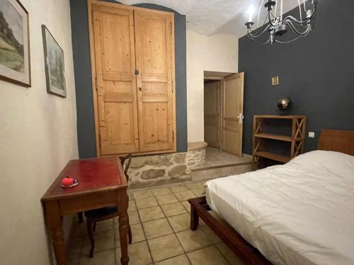 a bedroom with a bed and a wooden cabinet at La Gandonne in Caderousse