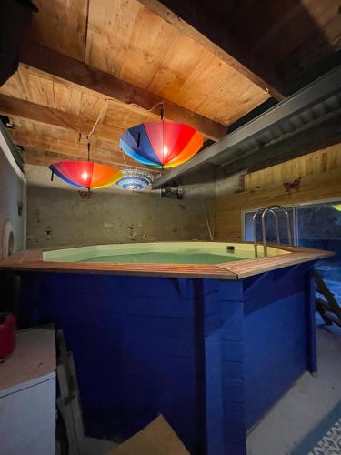 a kitchen with a counter with a sink and two umbrellas at La Gandonne in Caderousse