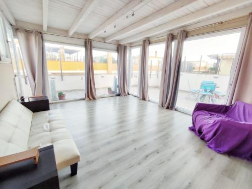 a large living room with a couch and large windows at Terrazza Lumière in Alezio