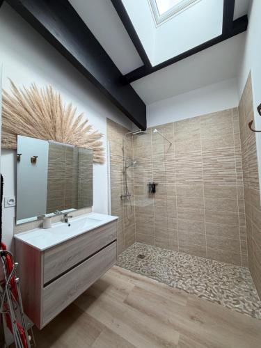 a bathroom with a sink and a shower and a mirror at Le rivage 44 in Bénouville