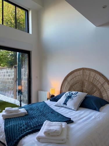 a bedroom with a large bed with towels on it at Le rivage 44 in Bénouville