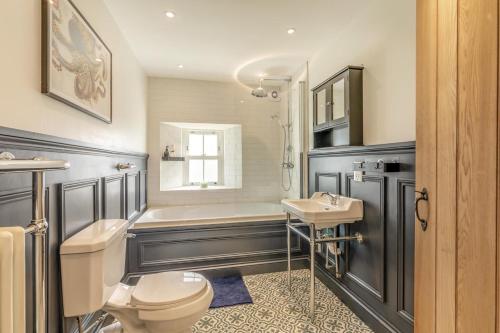 a bathroom with a toilet and a tub and a sink at 2 Bed in Caldbeck oc-b38644 in Caldbeck