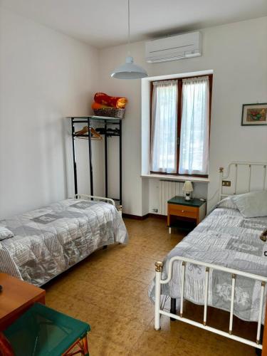 a bedroom with two beds and a window at Casa Olinda in Lazise