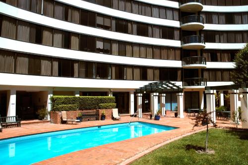 un hotel con piscina frente a un edificio en BreakFree Capital Tower Apartments, en Canberra