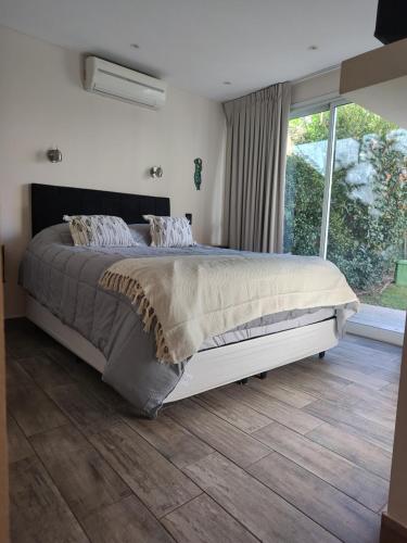 a bedroom with a large bed and a large window at Casa chacras in Chacras de Coria