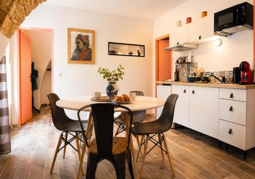 a kitchen and dining room with a table and chairs at L'écrin du Pont du Gard - Parking gratuit - Charme & Pierres in Remoulins